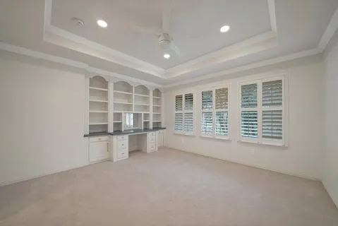 a view of a livingroom with an empty space & a window