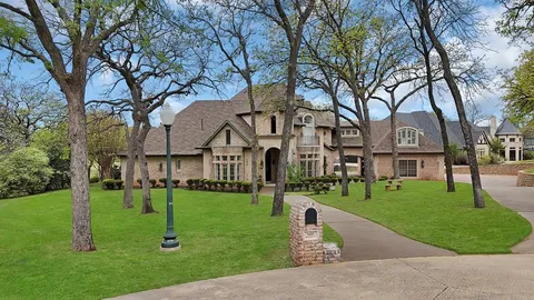 an aerial view of a house with a yard and large tree