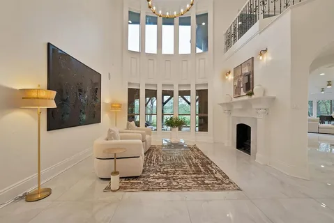 a living room with furniture a fireplace and a floor to ceiling window