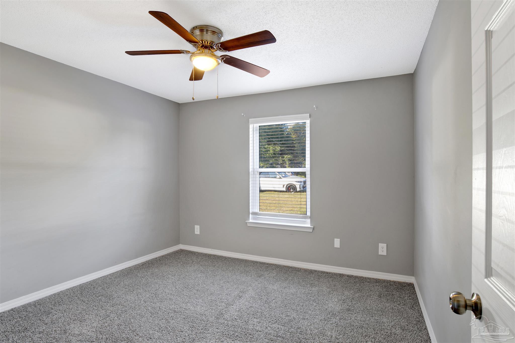 5801 Loring Drive Milton, FL 32583 - Photo 16 of 27 an empty room with a window and a ceiling fan