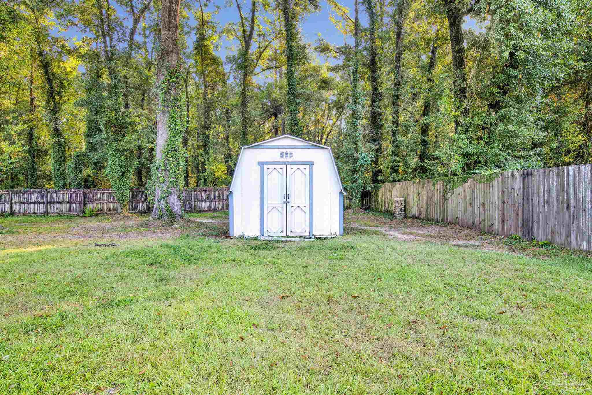5801 Loring Drive Milton, FL 32583 - Photo 21 of 27 a backyard of a house with plants and large trees