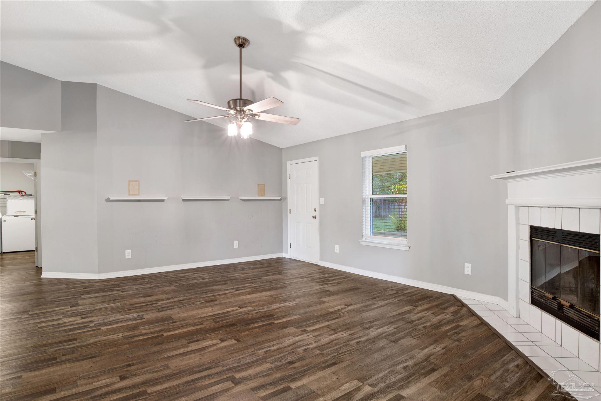 5801 Loring Drive Milton, FL 32583 - Photo 4 of 27 a view of wooden floor fire place refrigerator and window in a room