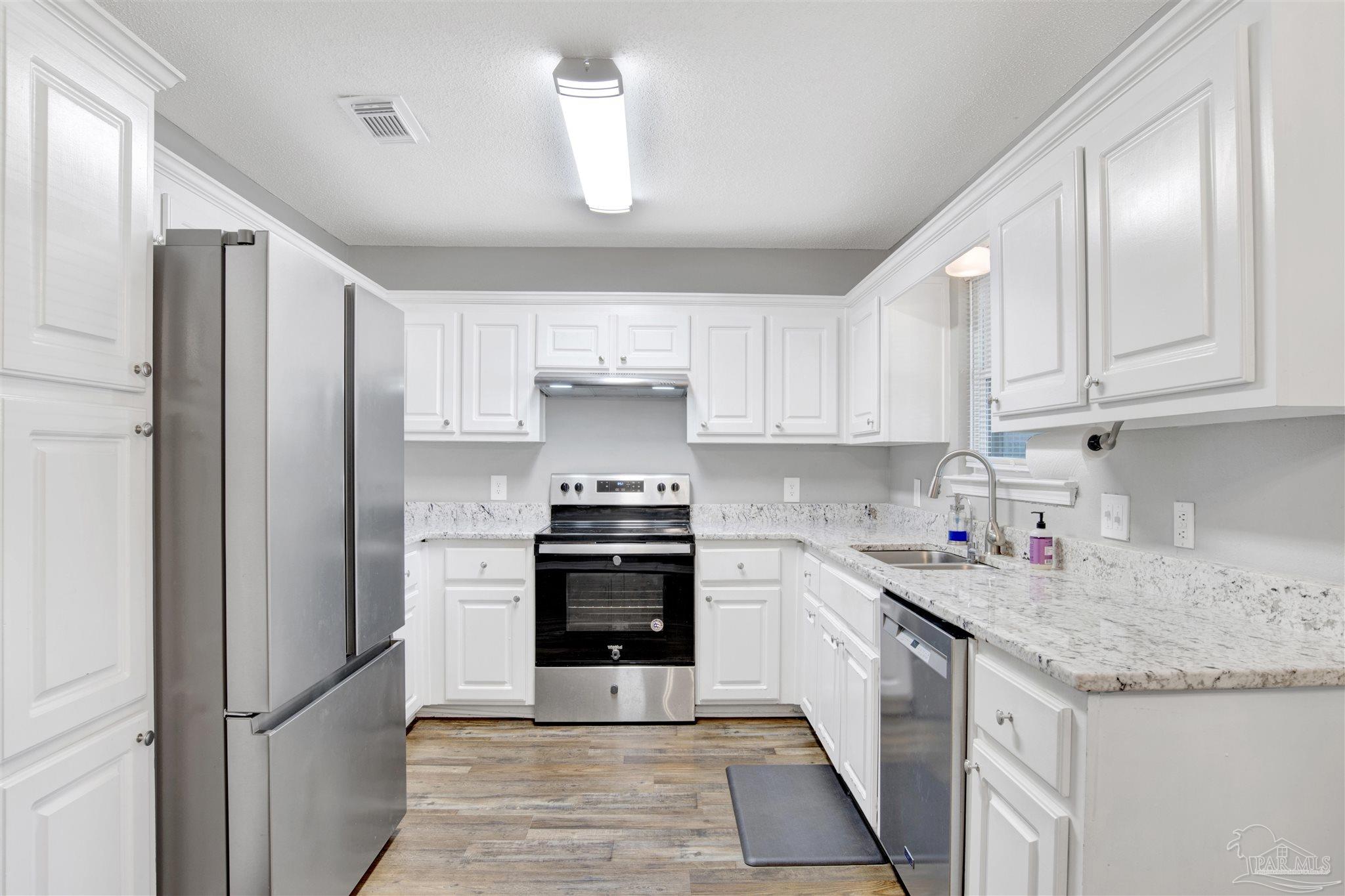5801 Loring Drive Milton, FL 32583 - Photo 8 of 27 a kitchen with stainless steel appliances granite countertop a refrigerator sink and cabinets