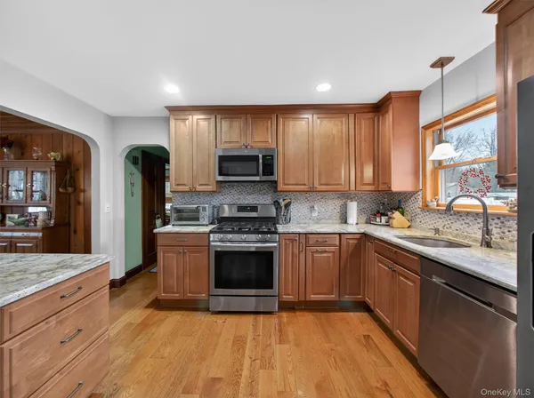 a large kitchen with stainless steel appliances granite countertop a stove a sink and a refrigerator