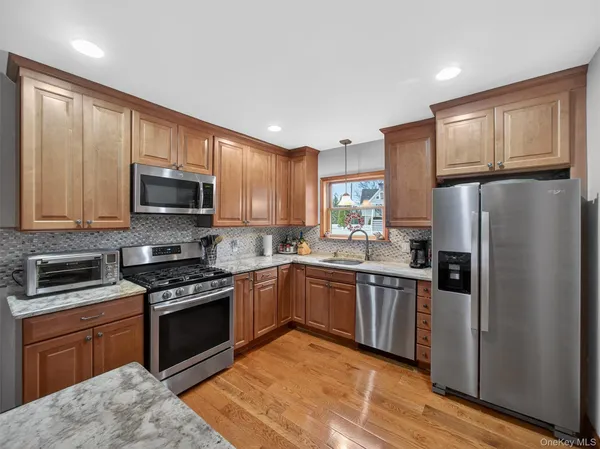 a kitchen with stainless steel appliances granite countertop a refrigerator stove microwave and sink