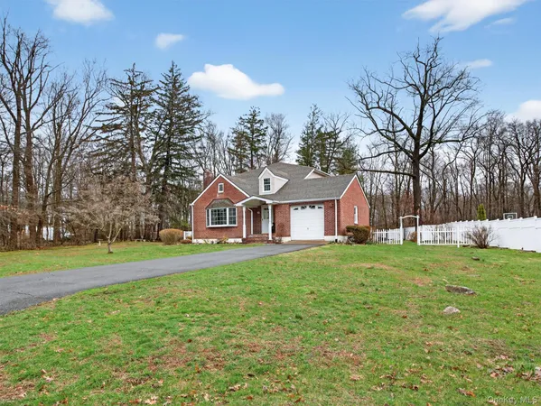a front view of a house with a yard and trees