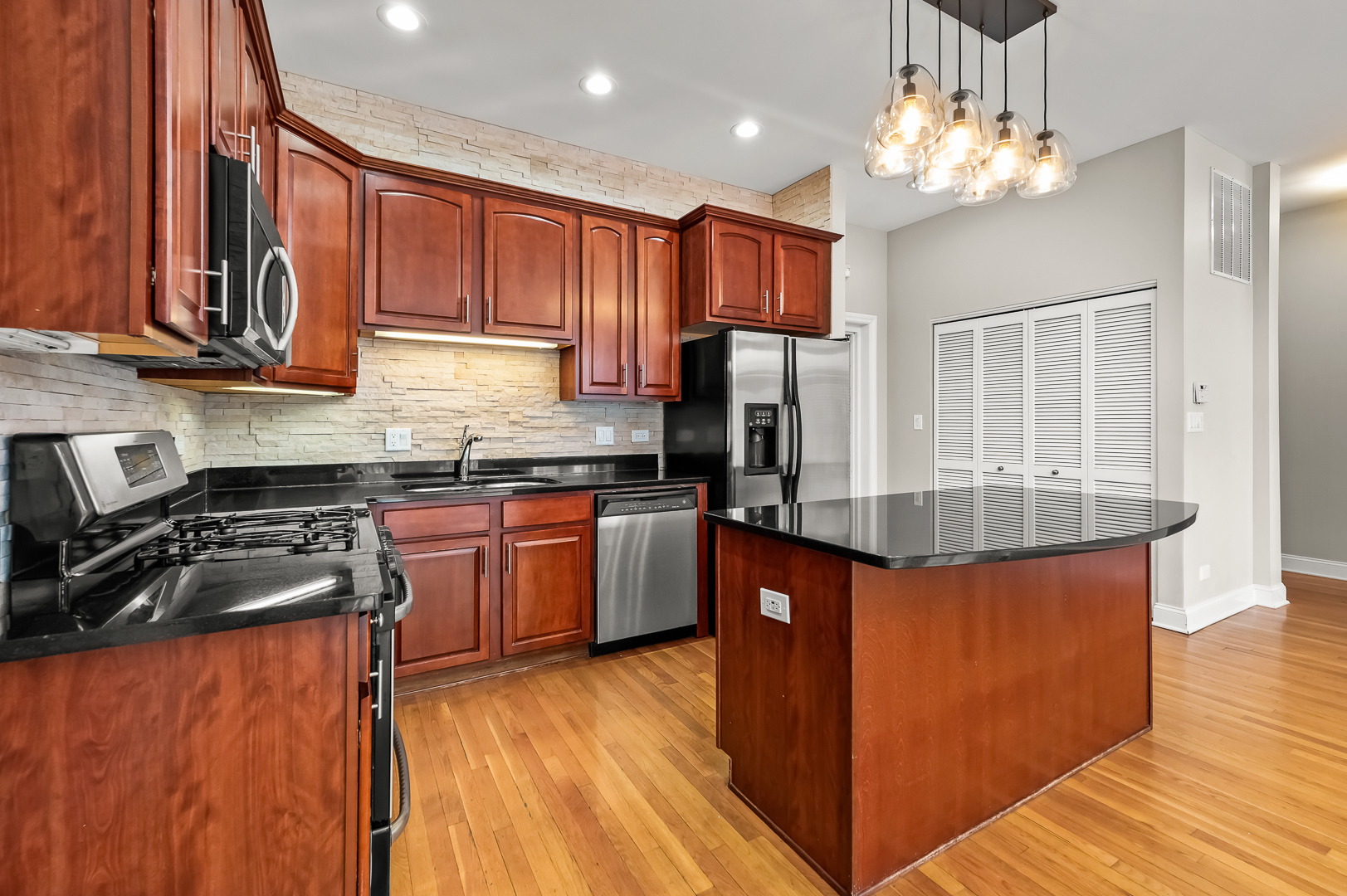 1408 West Taylor Street, Unit 301 Chicago, IL 60607 - Photo 8 of 21 a kitchen with stainless steel appliances granite countertop a refrigerator a sink dishwasher a stove and a dining table with wooden floor