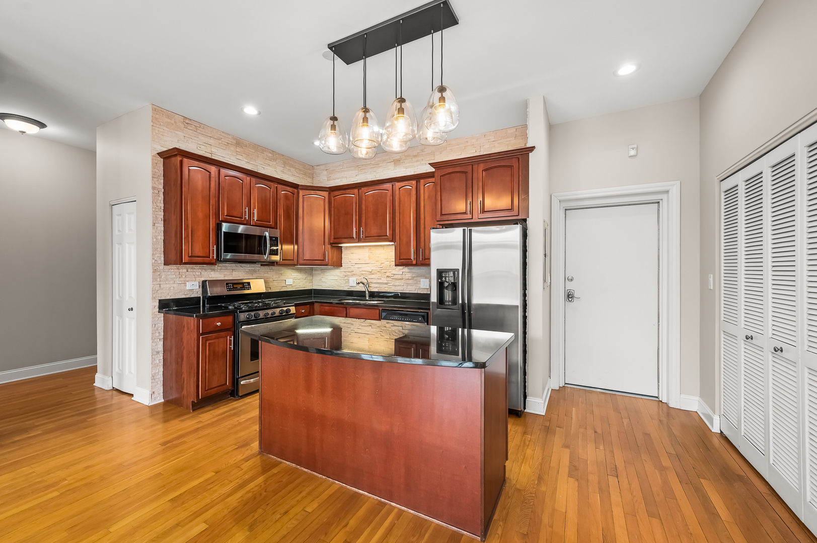 1408 West Taylor Street, Unit 301 Chicago, IL 60607 - Photo 9 of 21 a kitchen with stainless steel appliances granite countertop a refrigerator a stove top oven a sink dishwasher and wooden floor