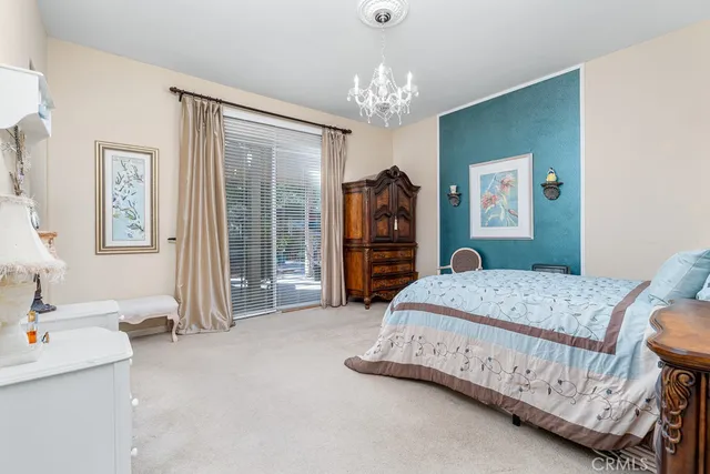 a spacious bedroom with a bed a desk and chair