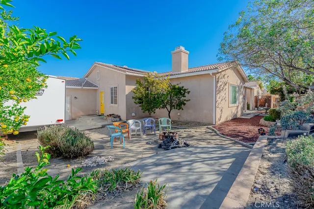 a view of a house with backyard sitting area and garden