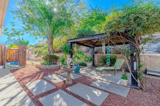 a view of a backyard with plants and chairs