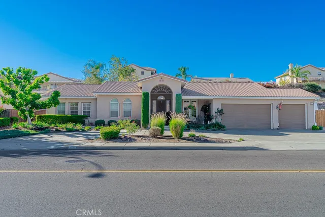 a front view of a house with a yard and potted plants