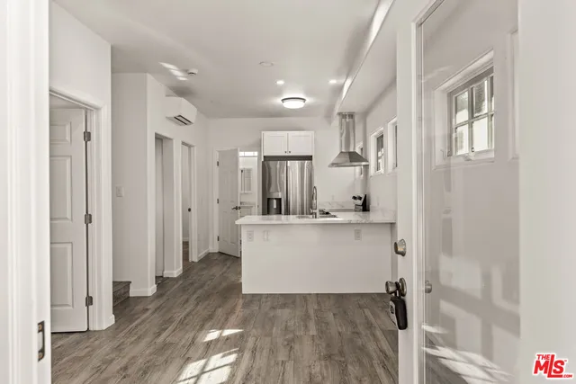 a room with white cabinets and wooden floor