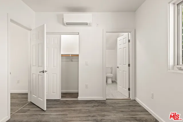 a bathroom with a granite countertop toilet sink and mirror