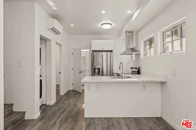 a view of kitchen with stainless steel appliances granite countertop cabinets and wooden floor