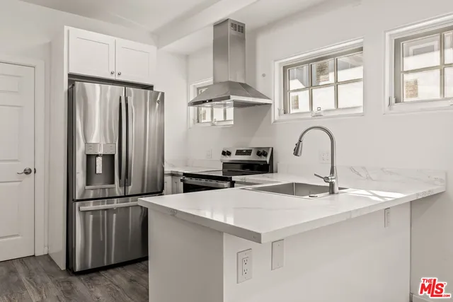 a kitchen with kitchen island a refrigerator stove and sink