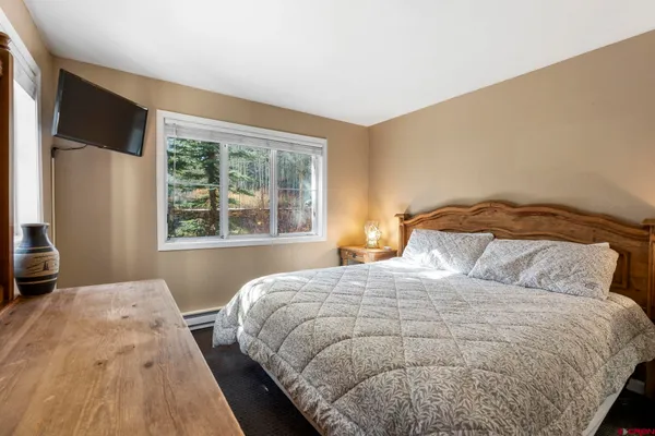a bedroom with a bed and a large window
