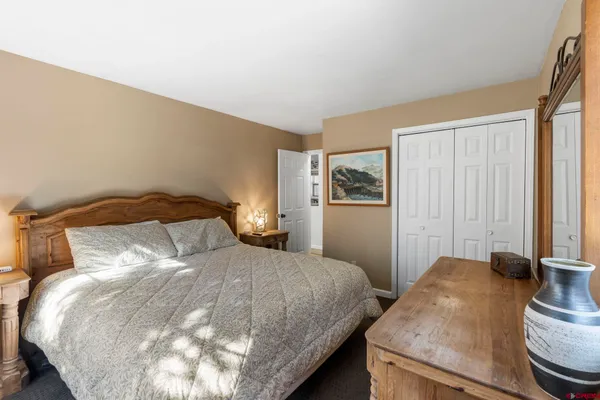 a bedroom with a bed and painting on the wall