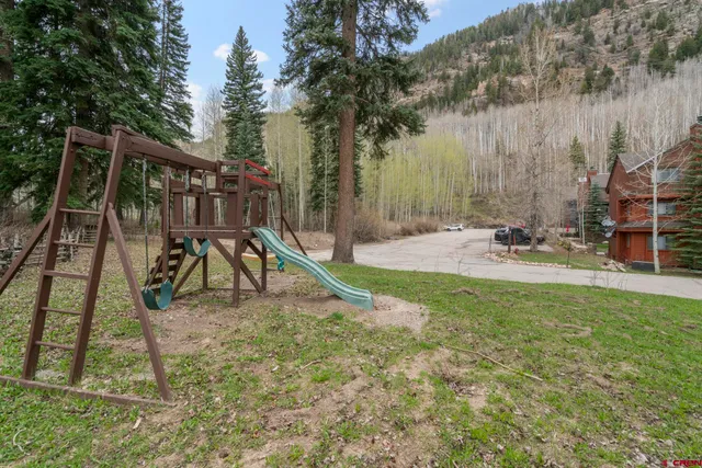 a view of a house with a wooden deck and a floor to ceiling window