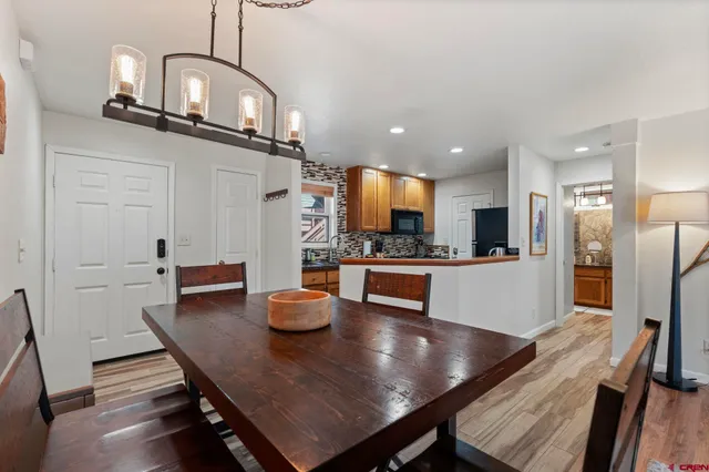 a kitchen with stainless steel appliances kitchen island granite countertop a table chairs in it and wooden floors