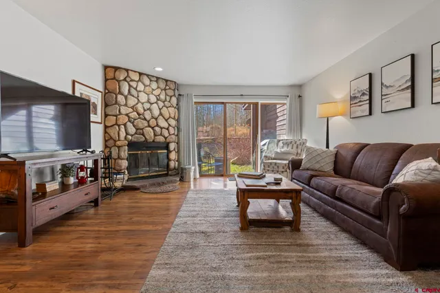 a living room with furniture a large window and a flat screen tv