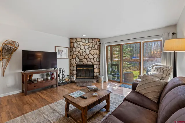 a living room with furniture a flat screen tv and a fireplace