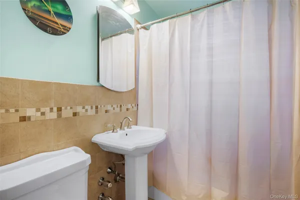 a bathroom with a sink a toilet and a mirror