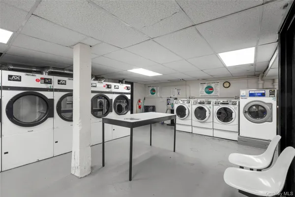 a utility room with dryer washer and a view of living room