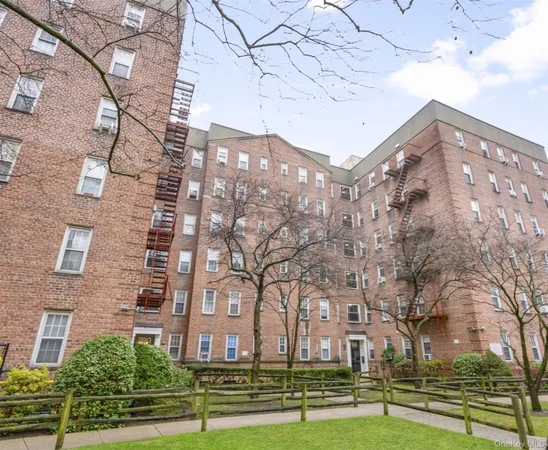 a view of a big building with a big yard and large trees