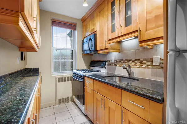 a kitchen with stainless steel appliances granite countertop a sink stove and cabinets