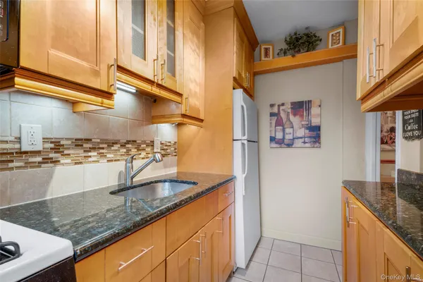 a view of a kitchen with stainless steel appliances granite countertop a sink and a counter space