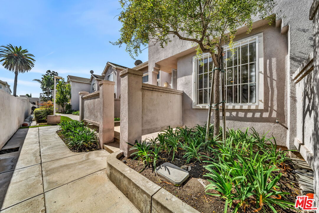 820 West Compton Boulevard, Unit 17 Compton, CA 90220 - Photo 4 of 50 a white house with a flower garden and potted plants