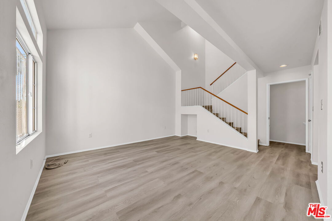 820 West Compton Boulevard, Unit 17 Compton, CA 90220 - Photo 6 of 50 a view of an empty room with wooden floor and stairs