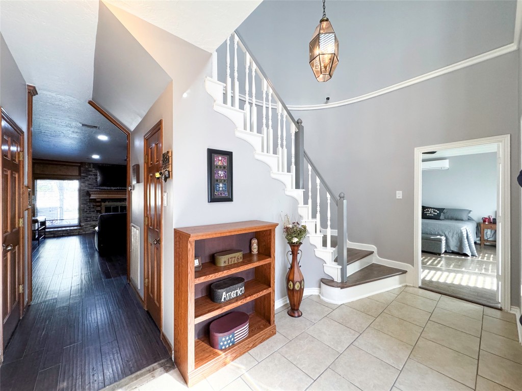 6618 Wimbledon Trail Road Spring, TX 77379 - Photo 4 of 43 This welcoming entryway features a tiled floor and a curved staircase with a modern light fixture overhead.