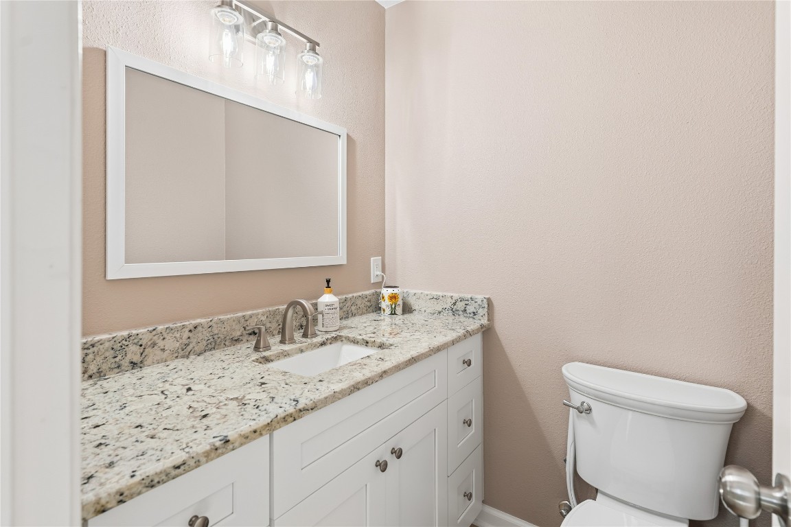 6618 Wimbledon Trail Road Spring, TX 77379 - Photo 7 of 43 This front half bath features a sleek design with a granite countertop, a white vanity with ample storage, modern fixtures, and a large mirror, complemented by neutral wall tones.