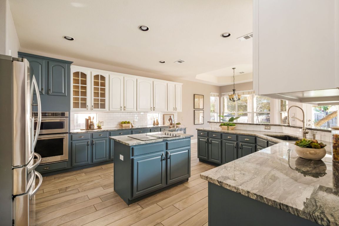 8101 Red Bird Court Austin, TX 78726 - Photo 12 of 33 a kitchen with a sink stove and cabinets