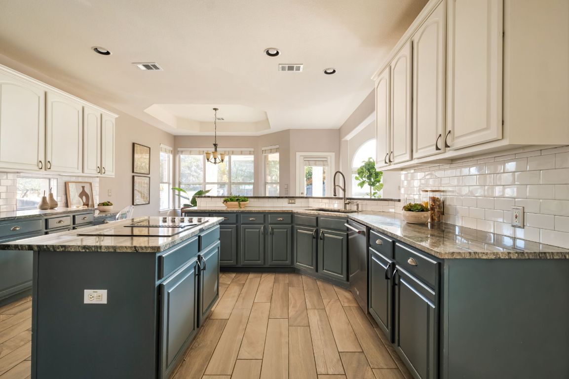 8101 Red Bird Court Austin, TX 78726 - Photo 13 of 33 a kitchen with stainless steel appliances granite countertop a sink stove and cabinets