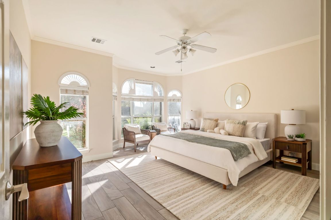 8101 Red Bird Court Austin, TX 78726 - Photo 19 of 33 a bedroom with a large bed and a chandelier