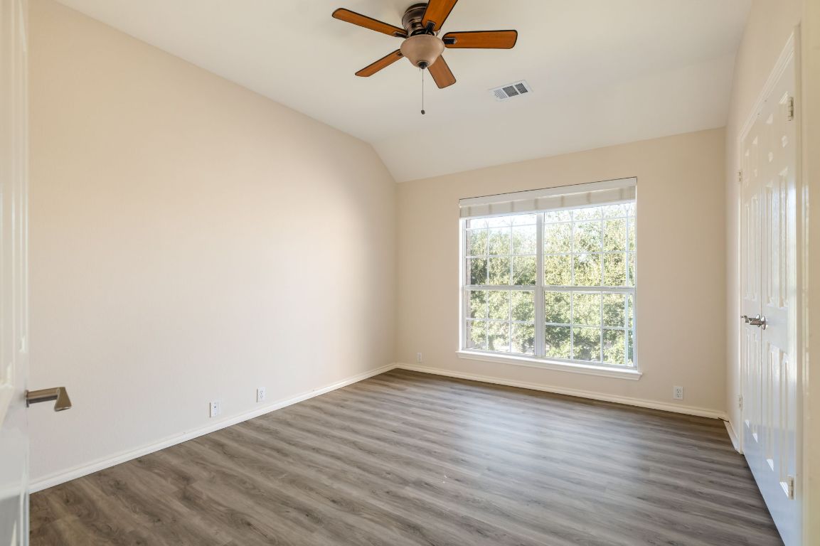 8101 Red Bird Court Austin, TX 78726 - Photo 28 of 33 an empty room with wooden floor fan and windows