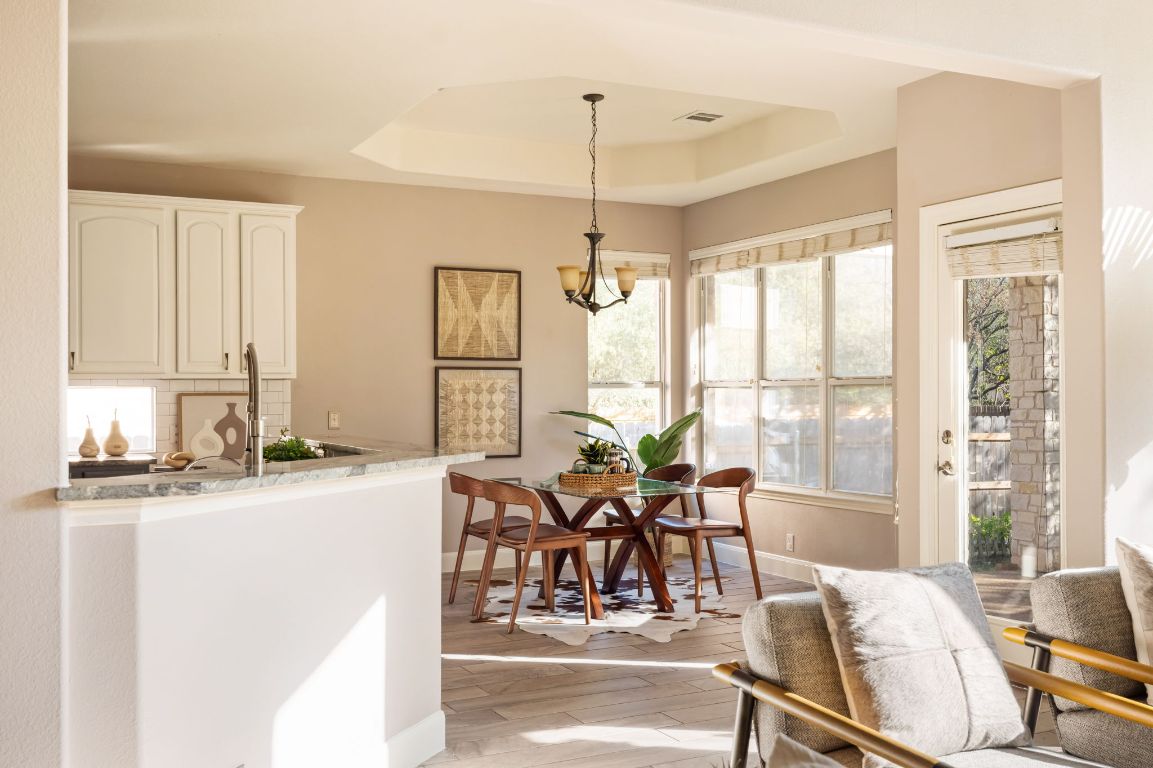8101 Red Bird Court Austin, TX 78726 - Photo 8 of 33 a dining room with furniture water view and a chandelier