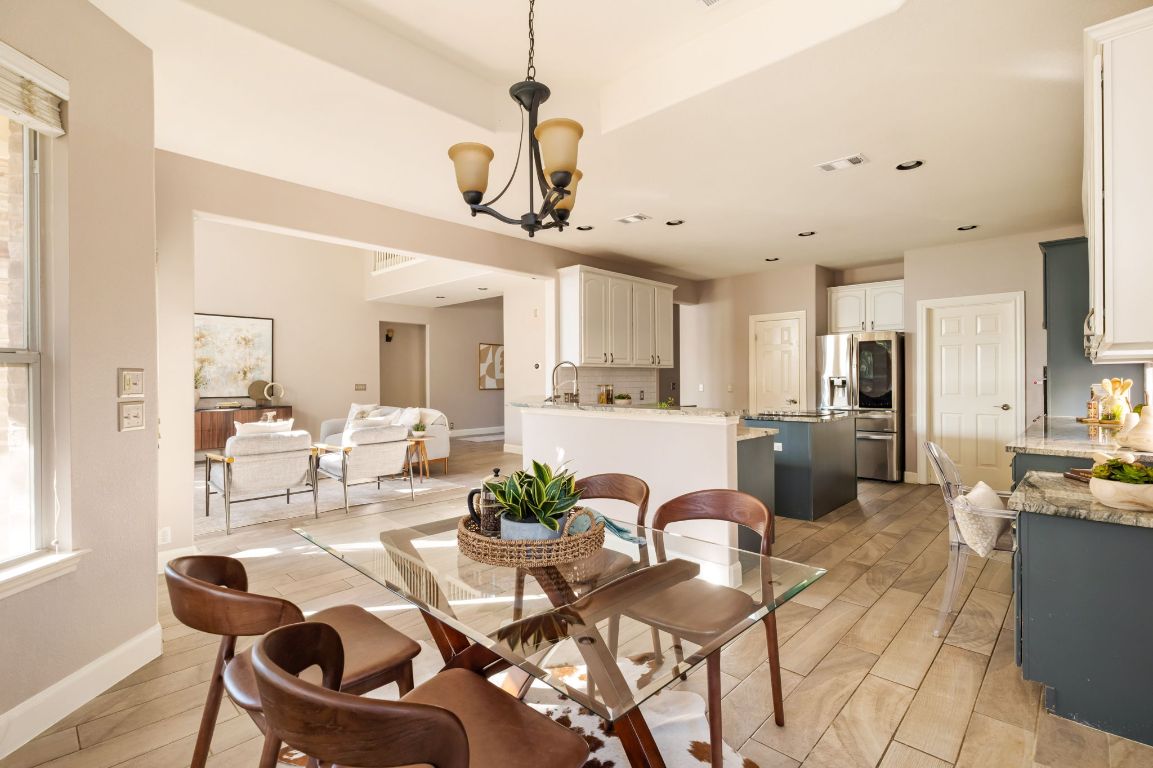 8101 Red Bird Court Austin, TX 78726 - Photo 10 of 33 a view of a dining room and livingroom with furniture wooden floor a chandelier