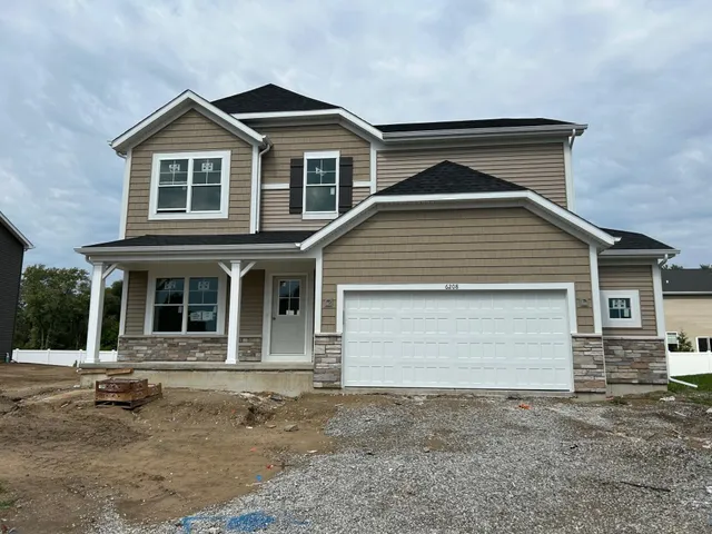 a front view of a house with a yard and garage