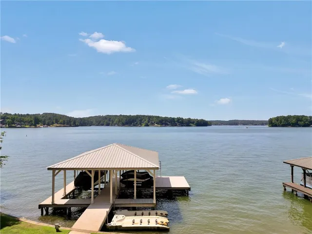 a kitchen with stainless steel appliances granite countertop a sink a stove cabinets a dining table and chairs