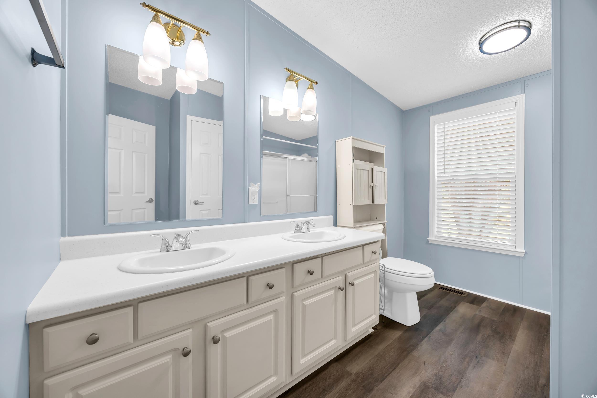 3373 Lake Pond Road Loris, SC 29569 - Photo 16 of 33 Bathroom featuring wood finished floors, double vanity, a shower, and a textured ceiling