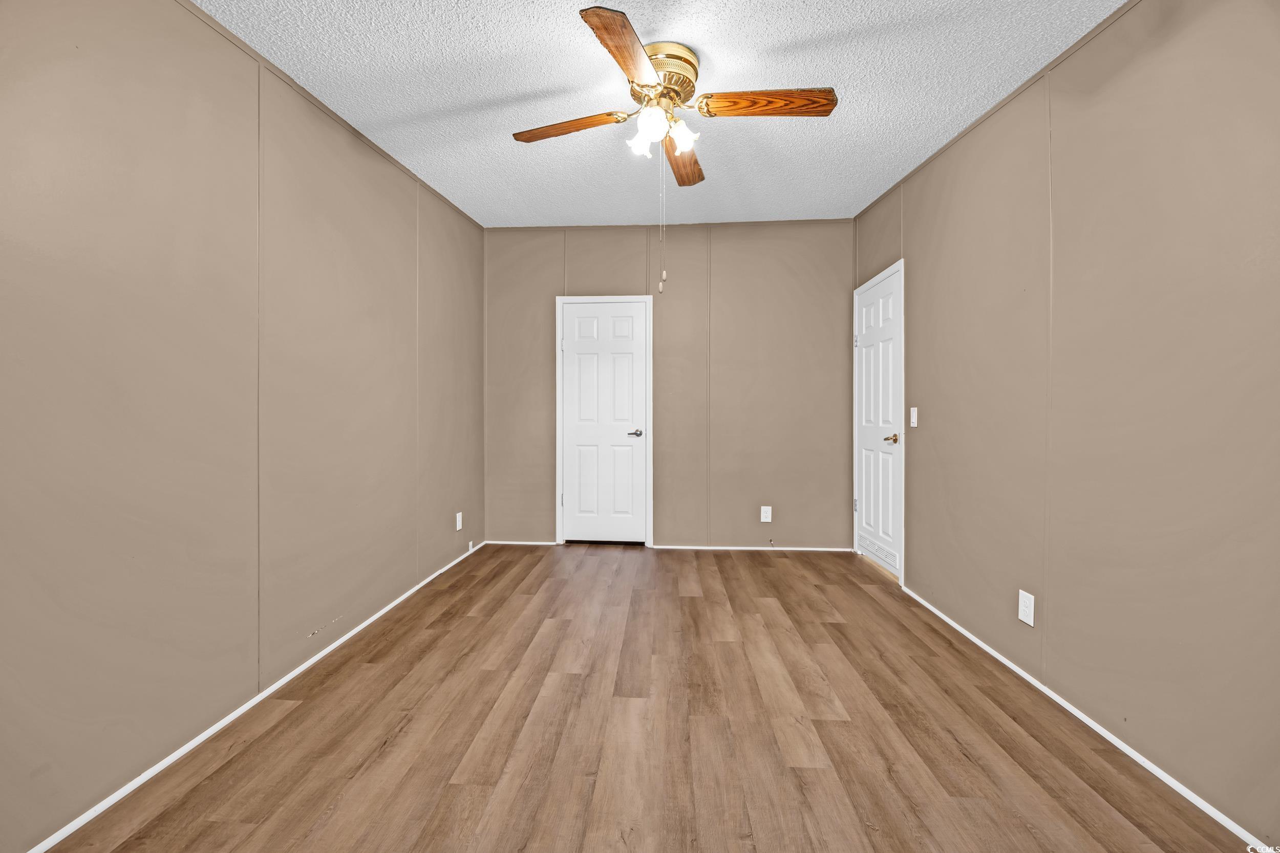 3373 Lake Pond Road Loris, SC 29569 - Photo 18 of 33 Unfurnished bedroom featuring wood finished floors, a textured ceiling, a decorative wall, and ceiling fan