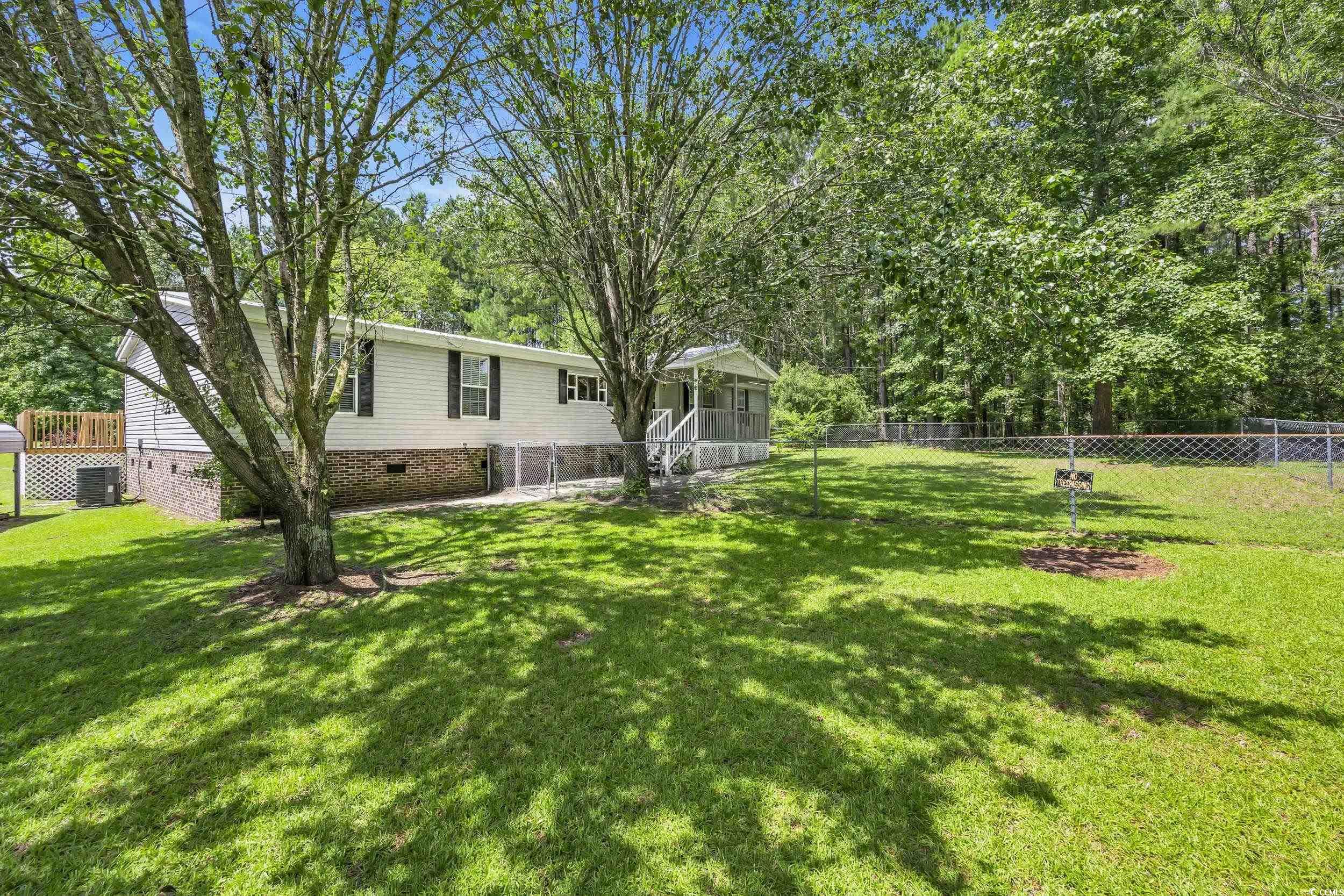 3373 Lake Pond Road Loris, SC 29569 - Photo 2 of 33 Fenced backyard with view of scattered trees and a sunroom