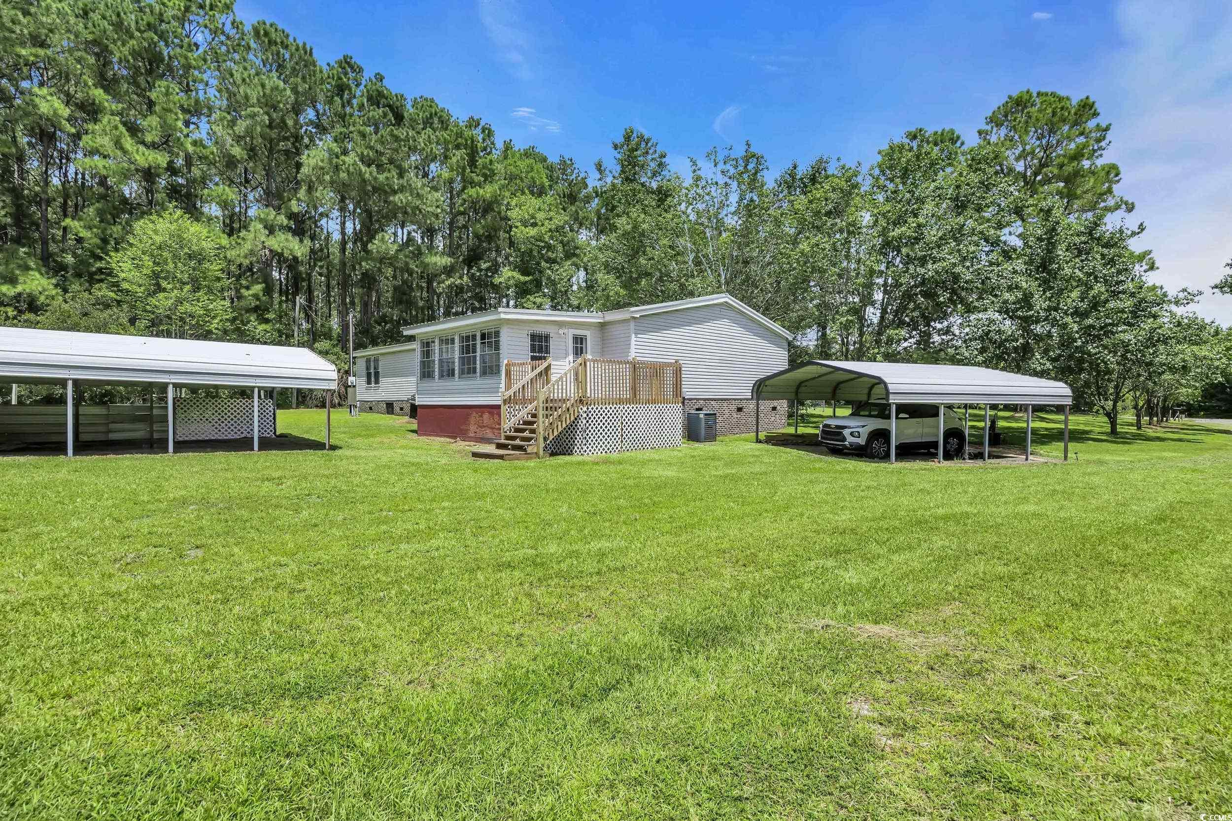3373 Lake Pond Road Loris, SC 29569 - Photo 25 of 33 Rear view of house with a carport, a lawn, view of scattered trees, and crawl space