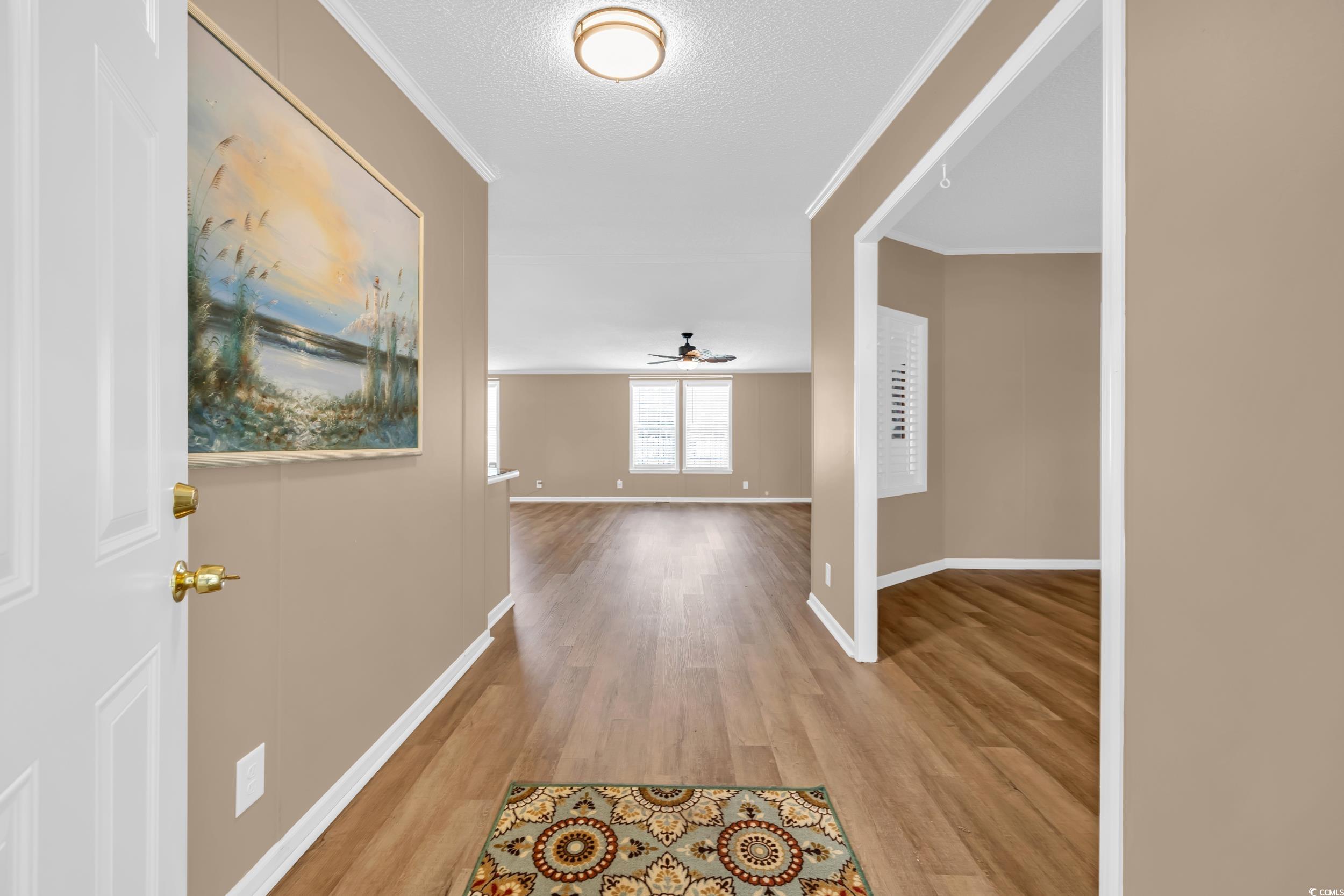 3373 Lake Pond Road Loris, SC 29569 - Photo 3 of 33 Hall featuring light wood-style flooring, a textured ceiling, and crown molding