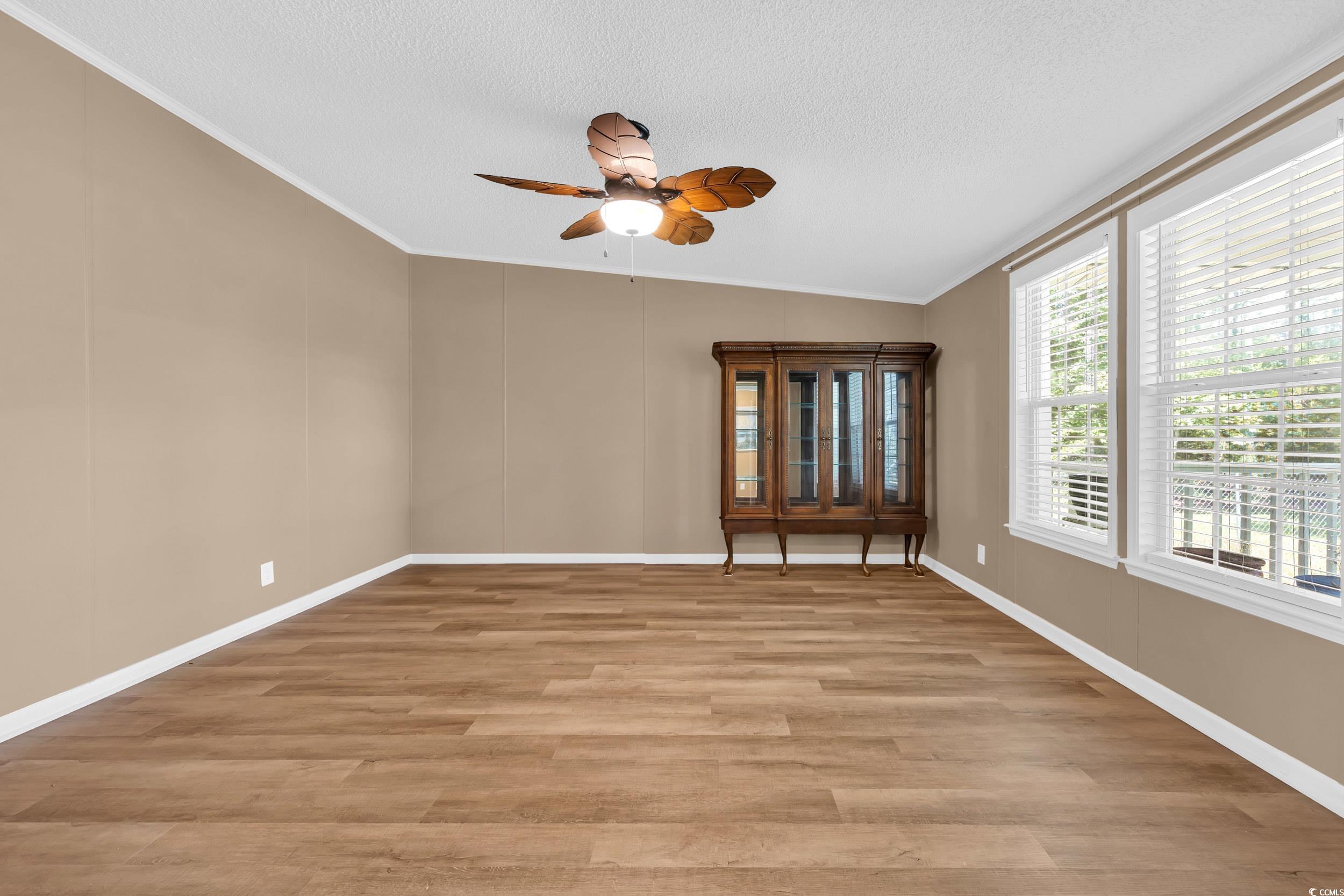 3373 Lake Pond Road Loris, SC 29569 - Photo 4 of 33 Empty room featuring ornamental molding, a ceiling fan, light wood-style flooring, and a textured ceiling