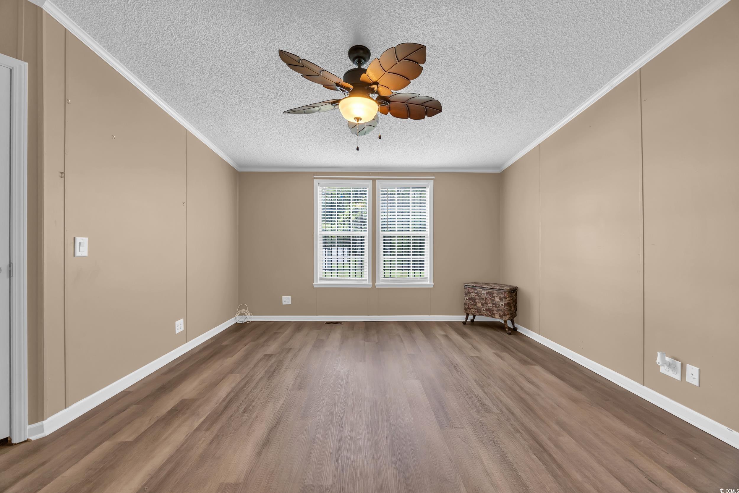 3373 Lake Pond Road Loris, SC 29569 - Photo 6 of 33 Unfurnished room featuring wood finished floors, ceiling fan, a textured ceiling, and crown molding